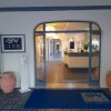 Entrata di un club con tappeto blu e insegna, reception visibile all'interno.
