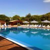 Piscina all'aperto con lettini e ombrelloni.