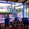 Tre seggioloni rosa per bambini vicino a finestre in un'area luminosa.