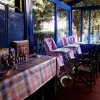 Una veranda con seggioloni per bambini, un tavolo con tovaglia a quadri e prodotti per bambini.