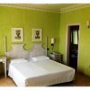 Camera d'albergo con pareti verdi e letto matrimoniale.