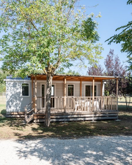 Casa mobile con veranda, alberi intorno.