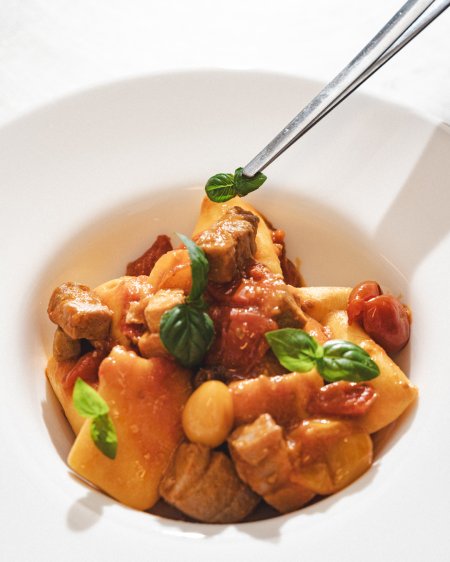 Piatto di pasta con pomodori e basilico.