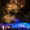Fuochi d'artificio sopra un palco con luci blu.