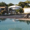 Piscina con sdraio e ombrelloni bianchi.