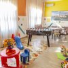 Sala giochi per bambini con calcetto, giocattoli colorati e pareti vivaci.