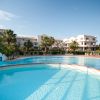 Piscina con hotel e palme sullo sfondo.