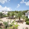 Giardino con palme e edifici bianchi tutt'intorno.