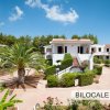 Complesso residenziale con giardino e palme.