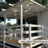 Terrazza con pergolato bianco e mobili da giardino.
