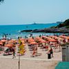 Spiaggia con ombrelloni arancioni e mare in lontananza.