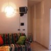 Salotto con divano, lampada e TV piccola.