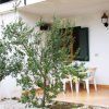 Terrazza con tavolo bianco e alberi circostanti.