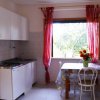 Cucina con tavolo, sedie e tendaggi rossi.