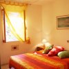 Camera da letto con letto colorato e tende gialle.