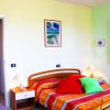 Camera da letto con letto colorato e finestra aperta.