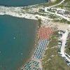 Vista aerea di una spiaggia con ombrelloni e mare.