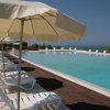 Piscina con lettini e ombrelloni in fila.