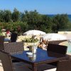 Tavolini all'aperto vicino a una piscina e al mare.