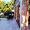 Terrazza esterna con tavoli e sedie vicino a un giardino.