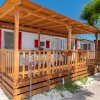 Chalet in legno con veranda e piante fiorite.