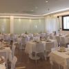 Sala da pranzo elegante, con tavoli apparecchiati con tovaglie bianche e sedie bianche.