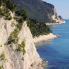 Scogliera verdeggiante che si estende lungo la costa blu.