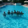 Sei persone in una piscina azzurra con cuffie da nuoto.