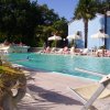 Piscina con lettini e ombrelloni bianchi.