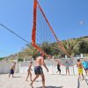 Persone giocano a beach volley sulla sabbia.