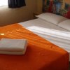 Letto matrimoniale con coperta arancione e asciugamani.