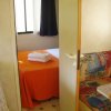 Camera con letto arancione e asciugamani piegati.