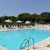 Piscina all'aperto con sdraio e ombrelloni.