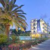 Hotel con palme e giardino al tramonto.