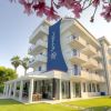 Hotel moderno con balconi e giardino fiorito.