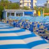 Ombrelloni blu e bianchi e un bar sulla spiaggia.
