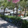 Giardino alberato con biciclette e area giochi per bambini.
