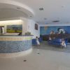 Reception con divani blu e murale colorato.