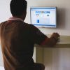 Persona seduta al computer, di schiena.