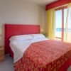 Letto matrimoniale con testiera rossa, vista sul mare.