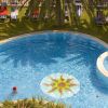 Piscina con decorazione solare e lettini sotto palme.