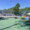 Campo sportivo all'aperto con canestro da basket.