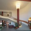 Ingresso elegante con scala curva e lampadario.