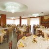 Sala da pranzo con tavoli apparecchiati e lampadari.