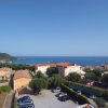 Vista panoramica sul mare con edifici residenziali e parcheggio in primo piano.