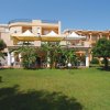 Edificio con terrazze e giardino rigoglioso con alberi e prati verdi.