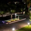 Una fontana illuminata di notte in un giardino.