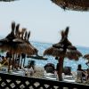 Spiaggia con ombrelloni di paglia e sdraio.