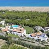 Vista aerea di un resort vicino al mare con piscina e vegetazione.
