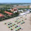 Spiaggia con ombrelloni e villette rosse in lontananza.